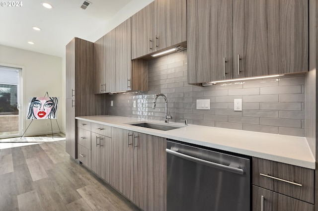 kitchen featuring dishwasher, light hardwood / wood-style flooring, sink, and decorative backsplash