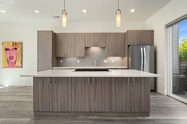 kitchen featuring light wood-type flooring, pendant lighting, and decorative backsplash