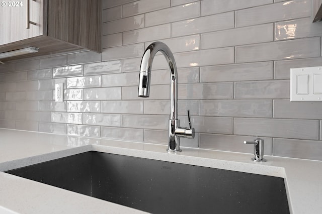 details with light stone counters, sink, and decorative backsplash