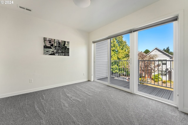 carpeted spare room with visible vents and baseboards