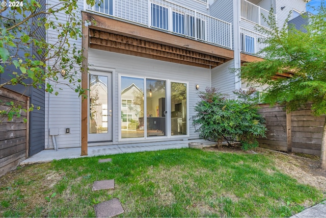 rear view of property featuring a yard and fence