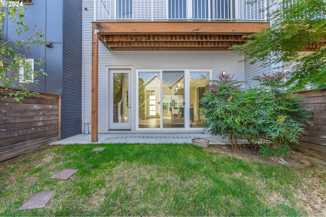 doorway to property with a patio area, a yard, and fence