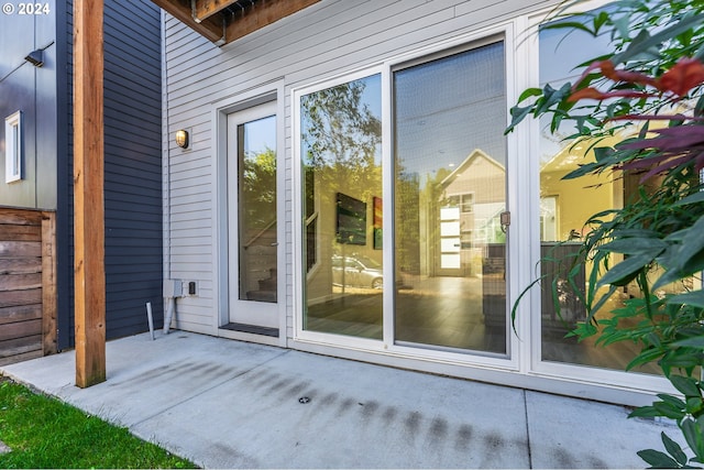 view of exterior entry with a patio