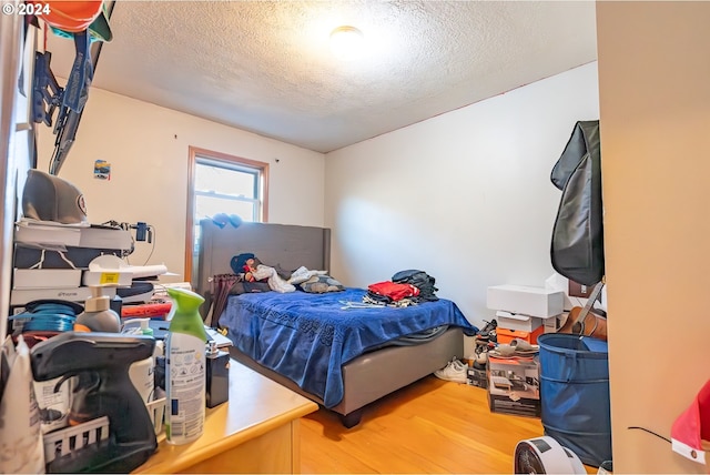 bedroom with hardwood / wood-style floors and a textured ceiling