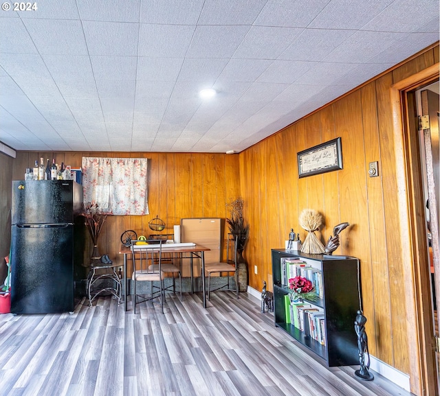 dining room with wood walls and light hardwood / wood-style floors