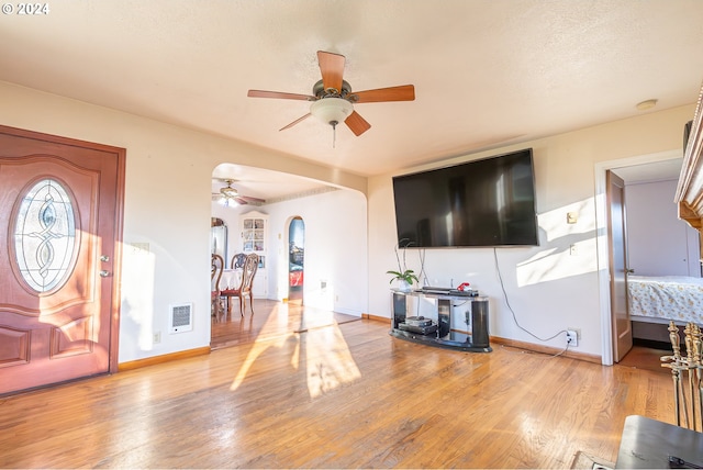 foyer entrance with ceiling fan and light hardwood / wood-style floors