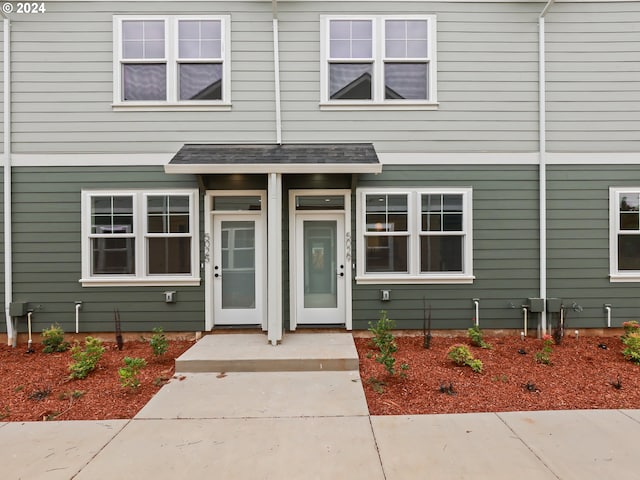 entrance to property featuring a shingled roof