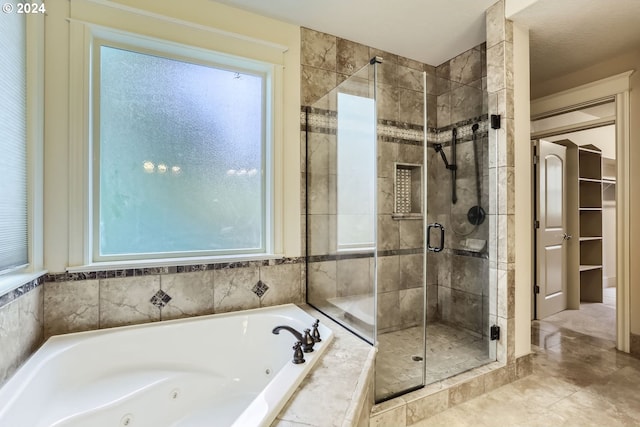 bathroom featuring tile patterned floors, a healthy amount of sunlight, a textured ceiling, and independent shower and bath