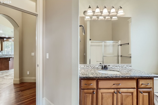 bathroom with vanity, hardwood / wood-style flooring, and a shower with shower door