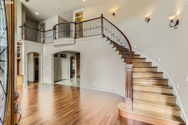 foyer entrance featuring hardwood / wood-style floors and a towering ceiling