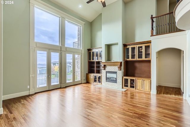 unfurnished living room featuring french doors, ceiling fan, high vaulted ceiling, a mountain view, and hardwood / wood-style floors