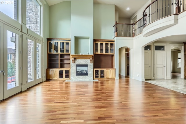 14815 SE Donley Ln, Happy Valley, OR 97086 - unfurnished living room with a towering ceiling, arched walkways, plenty of natural light, and wood finished floors