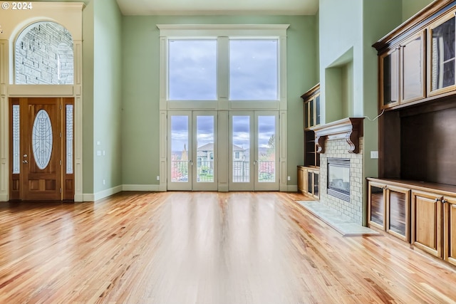 14815 SE Donley Ln, Happy Valley, OR 97086 - entryway with a high ceiling, light wood-style flooring, a fireplace with flush hearth, and baseboards