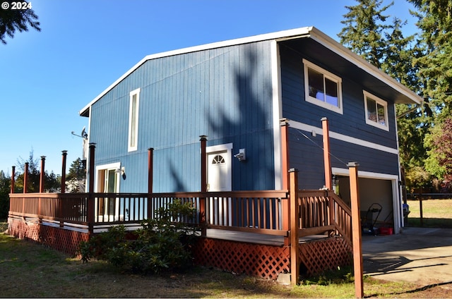 back of house with a garage and a wooden deck