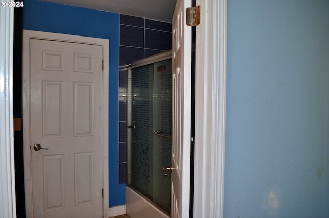 bathroom featuring bath / shower combo with glass door