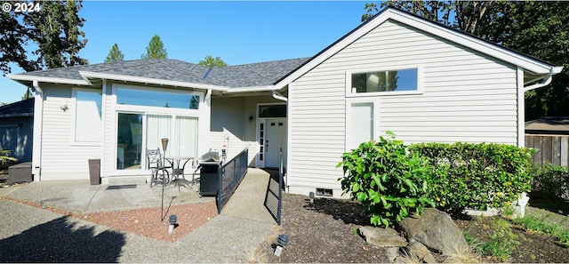 view of front of home with a shingled roof and a patio area