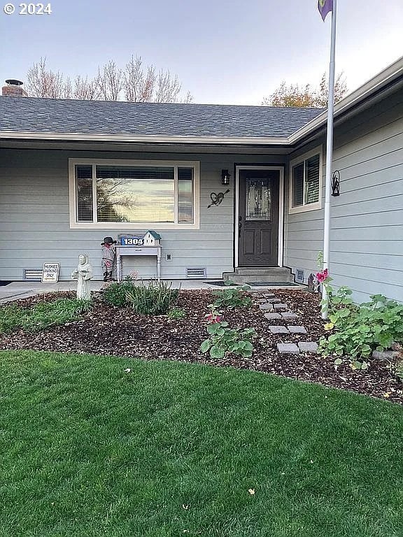 view of exterior entry with a lawn