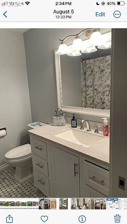 bathroom with toilet, vanity, and tile patterned flooring