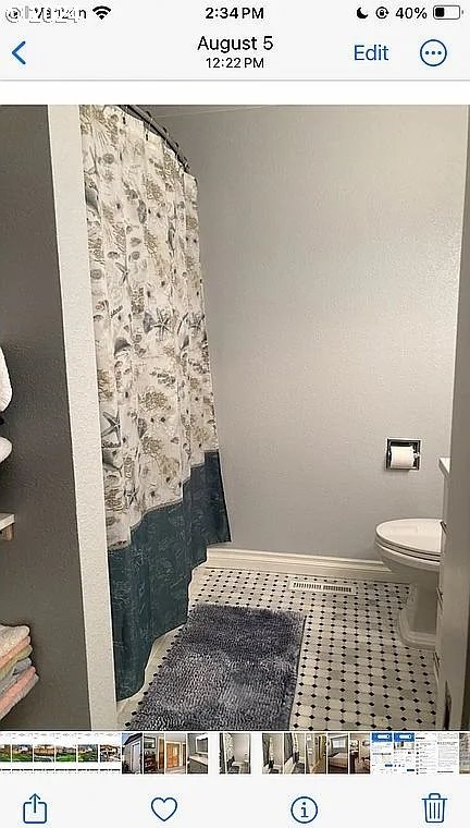 bathroom with a shower with shower curtain, toilet, and tile patterned flooring