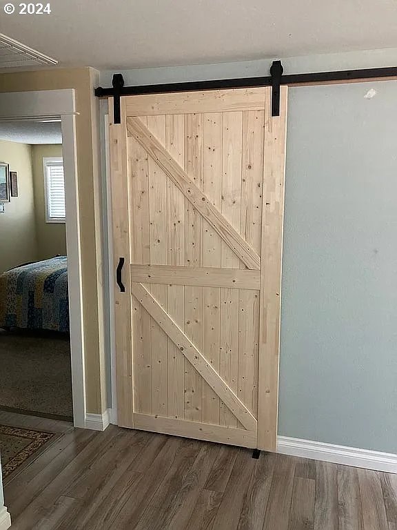 room details featuring hardwood / wood-style floors and a barn door