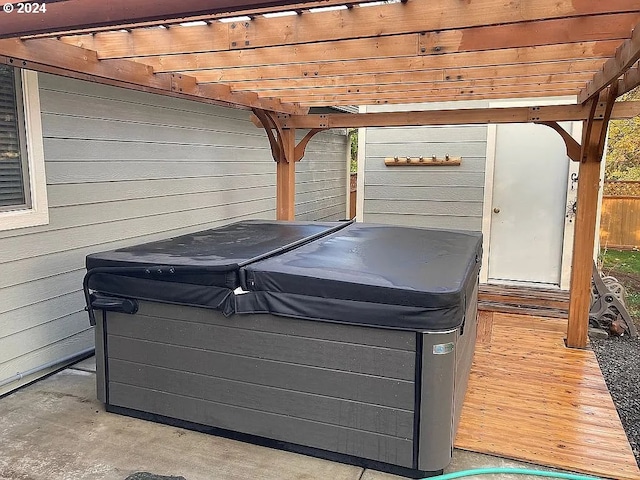 wooden deck with a hot tub and a pergola