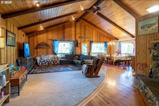 living room with ceiling fan, wood ceiling, beam ceiling, wooden walls, and wood-type flooring