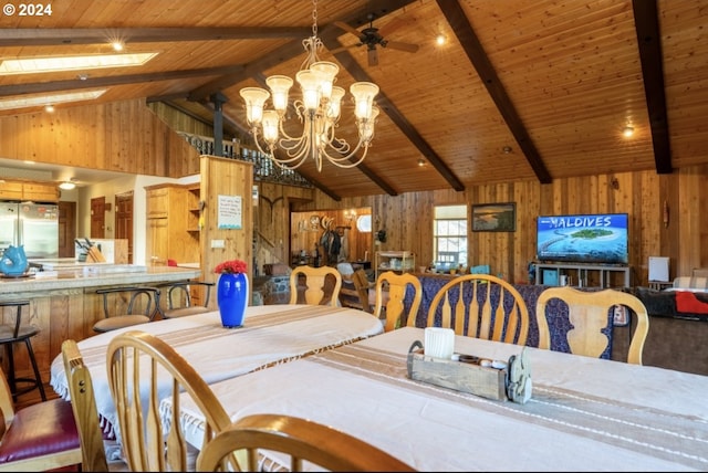 dining area featuring ceiling fan with notable chandelier, wooden ceiling, lofted ceiling with beams, and wooden walls