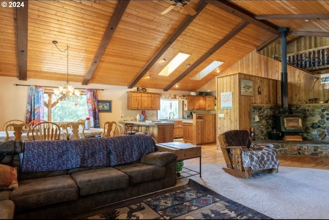 living room featuring wooden walls, a wood stove, wood ceiling, and light wood-type flooring