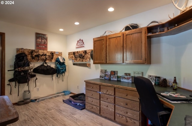 home office featuring light hardwood / wood-style flooring and built in desk