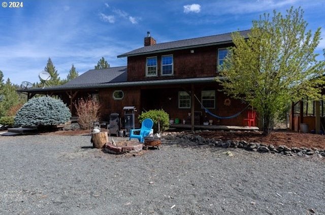 back of house featuring an outdoor fire pit