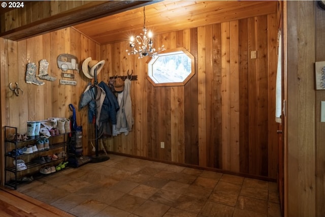 interior space with wood walls, a chandelier, and tile flooring