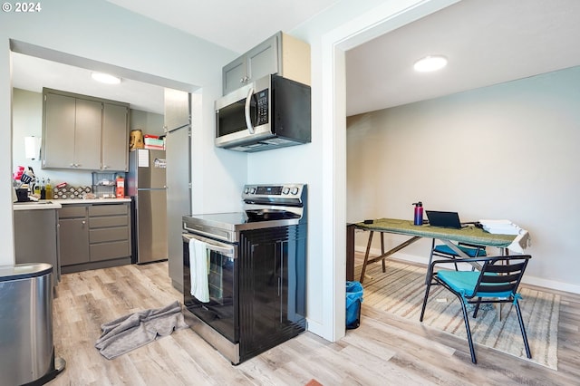 kitchen featuring appliances with stainless steel finishes, gray cabinetry, and light wood-type flooring