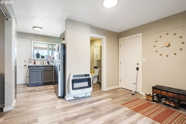 kitchen featuring sink, light hardwood / wood-style flooring, stainless steel refrigerator, and gray cabinets