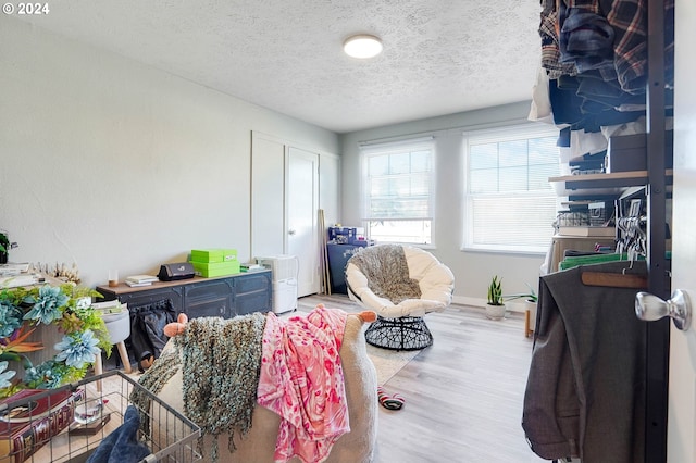 bedroom with light hardwood / wood-style floors and a textured ceiling