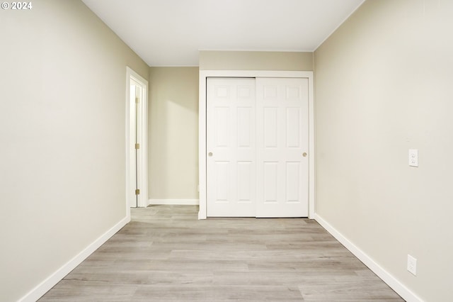 unfurnished bedroom featuring a closet and light wood-type flooring