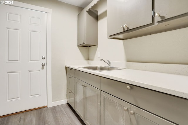 laundry area featuring light hardwood / wood-style floors and sink