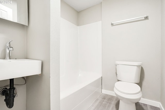 full bathroom featuring shower / washtub combination, hardwood / wood-style floors, sink, and toilet