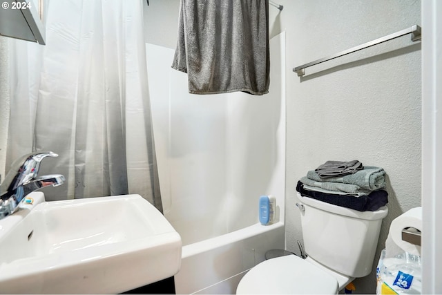 full bathroom with shower / tub combo with curtain, sink, and toilet