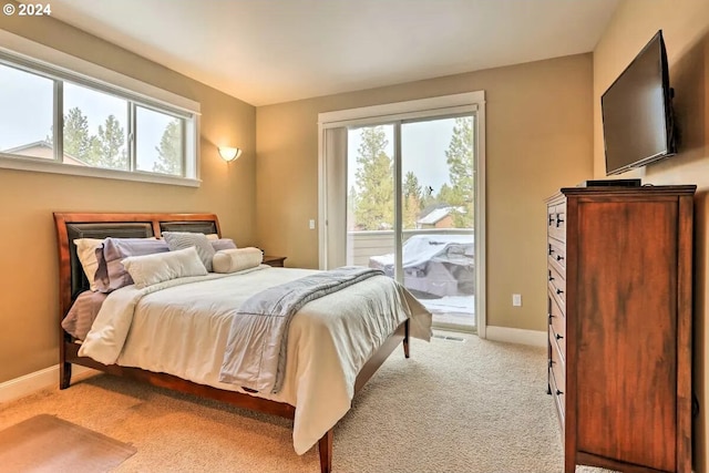 bedroom with access to exterior and light colored carpet