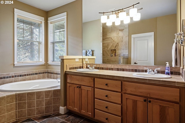 bathroom featuring a relaxing tiled tub and vanity