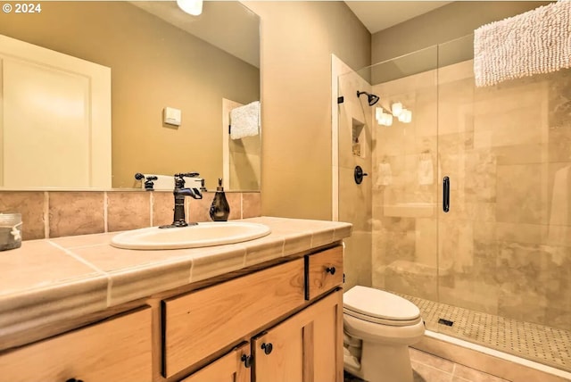 bathroom with vanity, toilet, tasteful backsplash, walk in shower, and tile patterned flooring