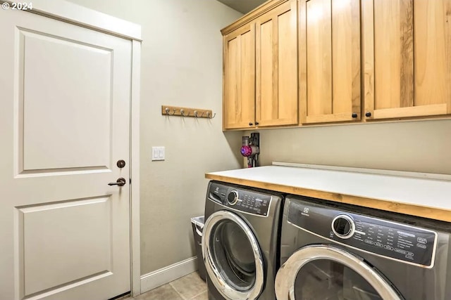 washroom with cabinets, washer and dryer, and light tile patterned flooring