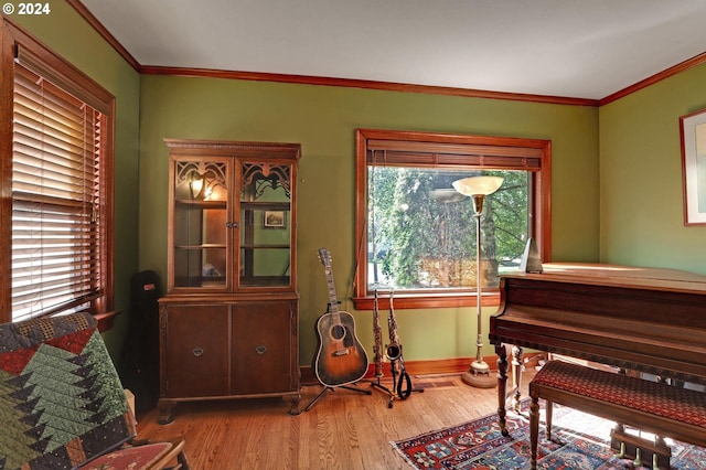 sitting room with crown molding, baseboards, and wood finished floors