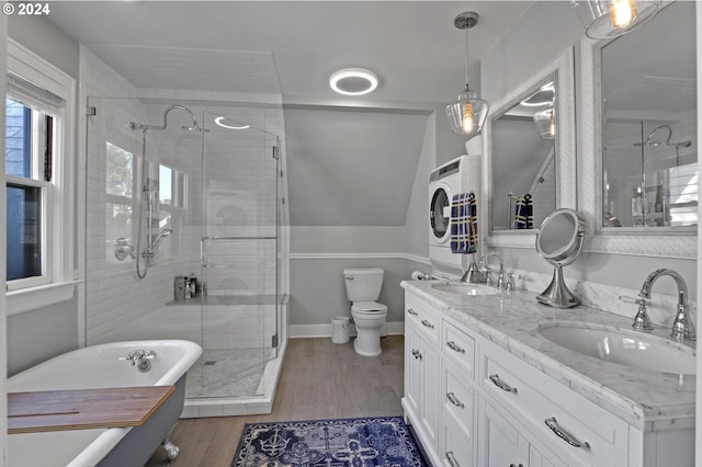 bathroom featuring toilet, washer / dryer, a sink, and a stall shower