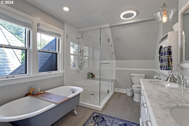 bathroom with wood finished floors, a sink, a freestanding bath, a shower stall, and double vanity