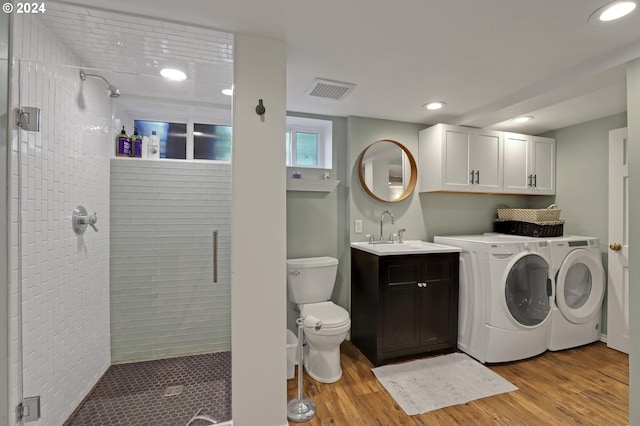 washroom featuring light wood-style flooring, laundry area, a sink, visible vents, and washer and clothes dryer