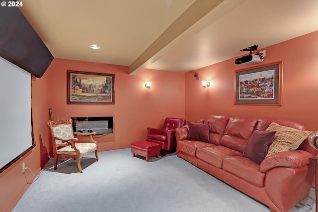 carpeted home theater with a glass covered fireplace, beamed ceiling, and baseboards