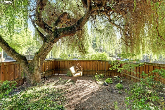 view of yard with a fenced backyard and a forest view