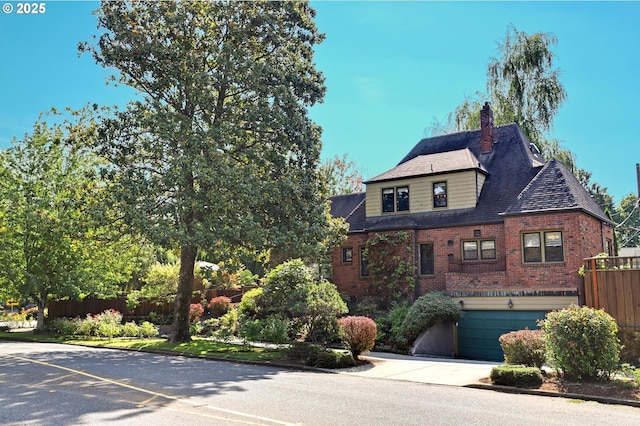 view of front facade featuring a garage, brick siding, fence, driveway, and a chimney