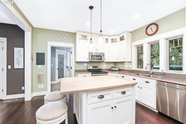 kitchen featuring white cabinetry, appliances with stainless steel finishes, sink, and a kitchen island